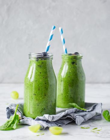 Zwei Glasflaschen mit grünem Detox-Smoothie im Cookit.