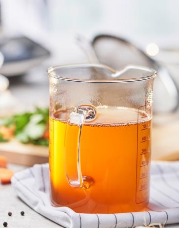 Fischfond in einem Messbecher.