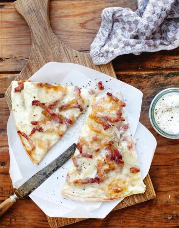Zwei Flammkuchenstücke auf einem Teller.