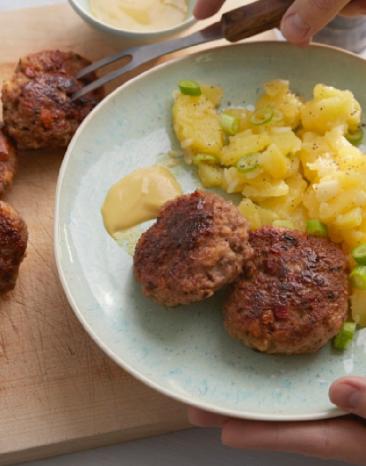 Frikadellen mit Kartoffelsalat auf einem Teller.