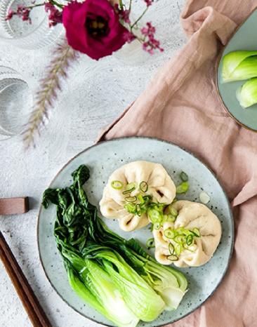 Teigtaschen gedämpft mit Schweinefleisch und Pak Choi auf eine Tisch.