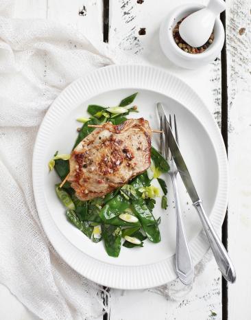 Gefüllte Kalbsrückensteaks mit Ziegengouda auf einem Bett aus Zuckerschoten.