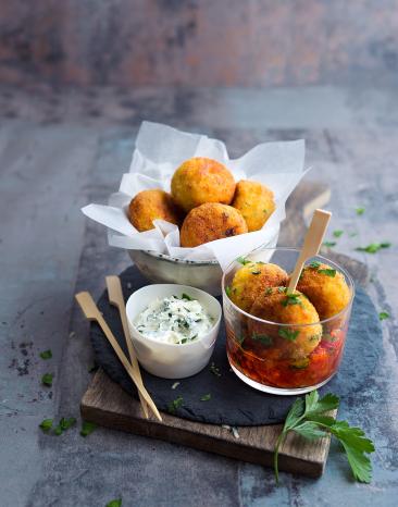 Gemüsebällchen mit Käse in einem Körbchen mit Dip.