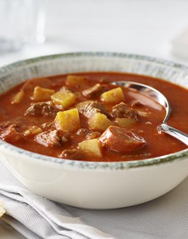 Gulaschsuppe in einem Suppenteller angerichtet.