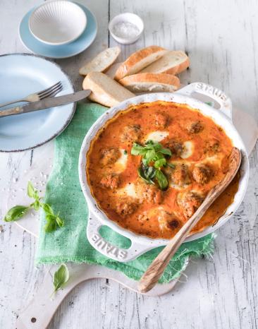 Hackbällchen Toskana in Auflaufform mit Basilikum garniert.