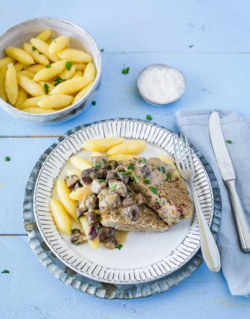Hackbraten mit Schupfnudeln und Champignon-Kräuter-Rahmsauce auf Teller.