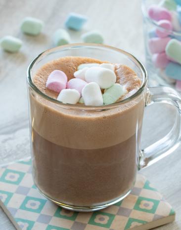 Heiße Schokolade im Glas mit bunten Marshmallows