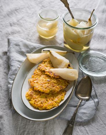 3 Puffer auf einem Teller mit Kompott und 3 Birnenschnitzeln verteilt