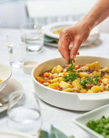 Kartoffelgulasch deftig in einer Schale, wird mit Petersilie garniert.