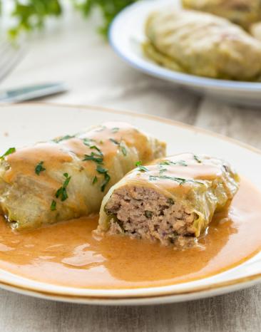 Kohlroulade mit Hackfleischfüllung auf einem Teller angerichtet.