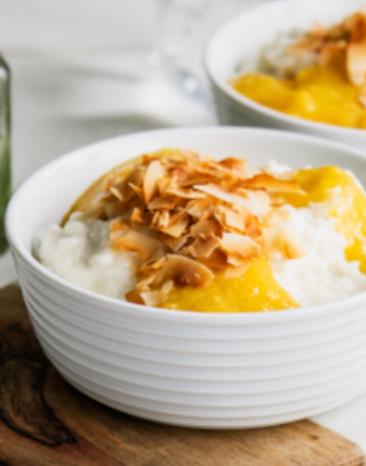 Kokosmilchreis mit Mangosoße in zwei Schalen angerichtet.