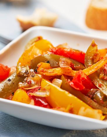 Letscho mit Peperoni in einer Schale angerichtet.