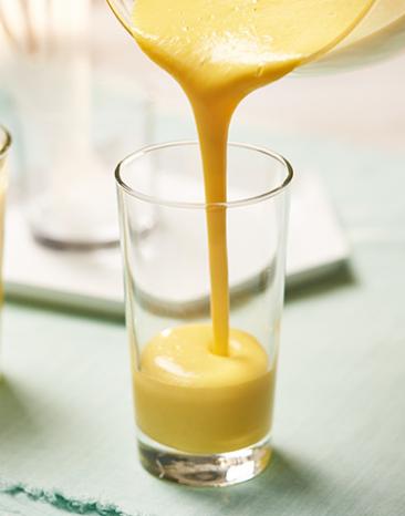 Mango-Lassi wird in ein Glas gegossen.