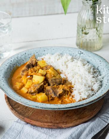 Massaman Curry mit Reis auf einem Teller serviert.