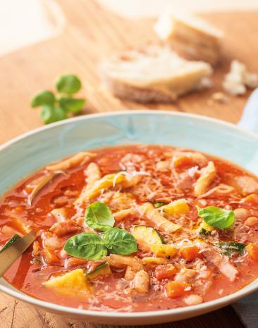 Minestrone mit Petersilie garniert in einem Teller serviert.