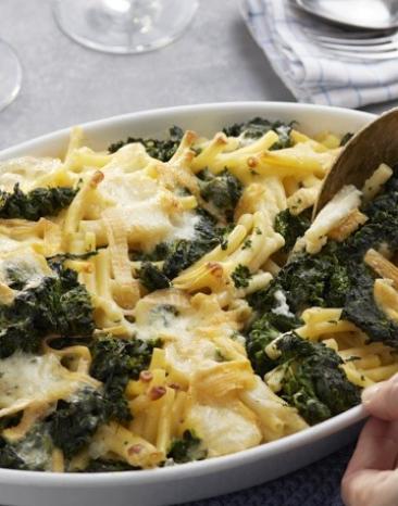 Nudelauflauf mit Spinat wird aus einer Auflaufform genommen.