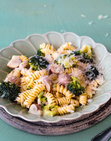 Nudeln mit Brokkoli und Pilzen in einem Teller.