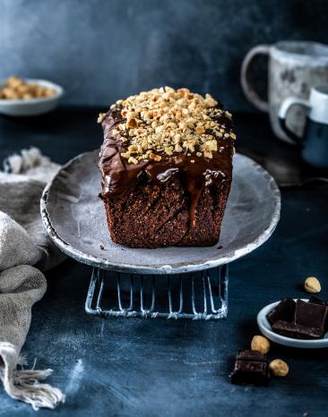 Nussiger Schokoladenkuchen auf einer Kuchenplatte.