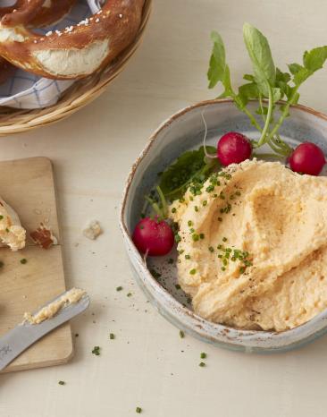 Obazda in einer Schale neben Brezel.