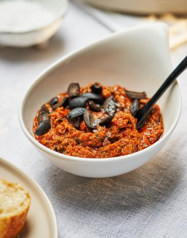 Pesto Rosso mit Oliven in einer Schale.