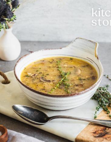 Pilz-Gersten-Suppe in einer Suppenschüssel mit Löffel.