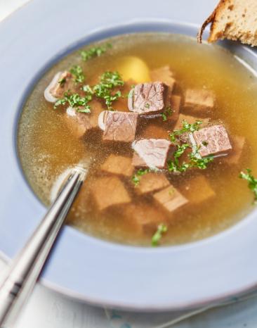 Rinderbouillon mit Einlage in einem Suppenteller.