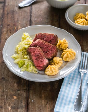 Rinderfilet sous-vide mit Herzoginkartoffeln auf einem Teller angerichtet