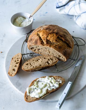 Angeschnittenes Roggen-Dinkel-Brot mit Frischkäse-Aufstrich.