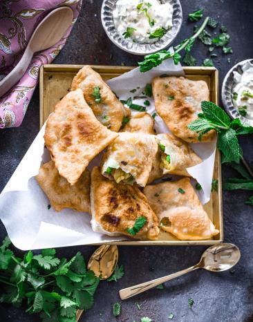 Samosas mit vegetarischer Füllung und Minz-Joghurt auf einem Teller