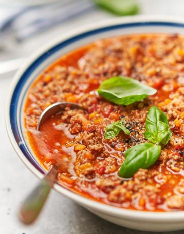 Sauce Ragout Bolognese mit Basilikum garniert in einer Schüssel.