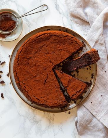 Schneller Rote-Bete-Schokoladenkuchen mit Mandeln auf einem Teller angerichtet.