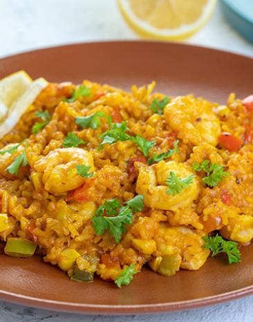 Spanischer Reis mit Garnelen auf einem Teller.