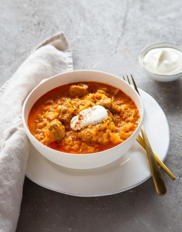 Szegediner Gulasch mit Creme fraîche garniert in Schüssel
