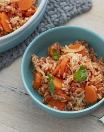 Tomatenreis mit Karotten und Petersilie in einer Schüssel.