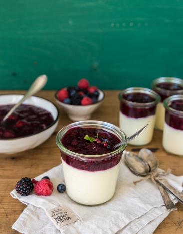 Vanillepudding mit Grütze in einer Schale auf einem Tisch.