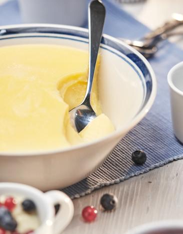 Vanillepudding in einer Schüssel mit einem Löffel.