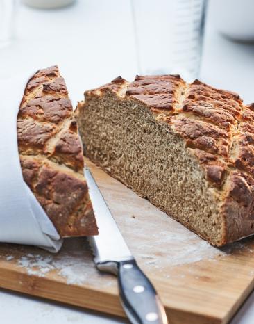 Weizen-Roggenbrot angeschnitten auf einem Holzbrett.