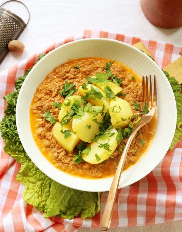 Wirsinggemüse mit Kartoffeln und Hackfleisch auf einem Teller angerichtet.
