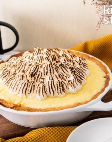 Zitronentarte mit Baiser in einer Backform auf einem Tisch.