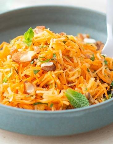 Karotten-Apfel-Salat mit Granola in großer Schale.