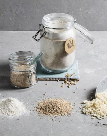 Mehlsorten in Gläsern und Kelle mit Mehl
