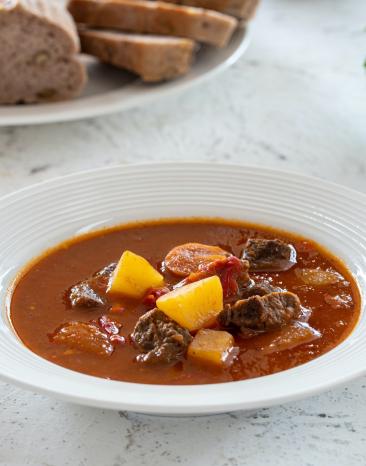 Ungarisches Gulasch mit Brot an der Seite.