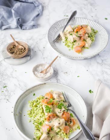 Low-Carb: Hühnerfrikassee mit Brokkoli-Blumenkohl-Reis auf zwei Tellern.