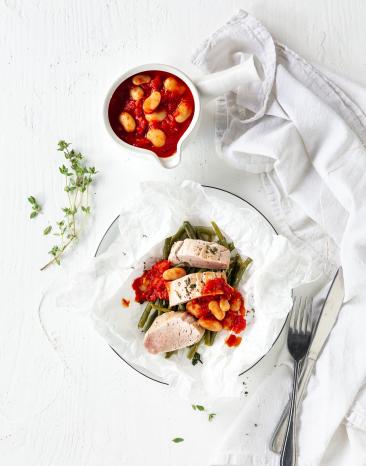 Schweinefiletmit Tomatensauce auf einem Teller.