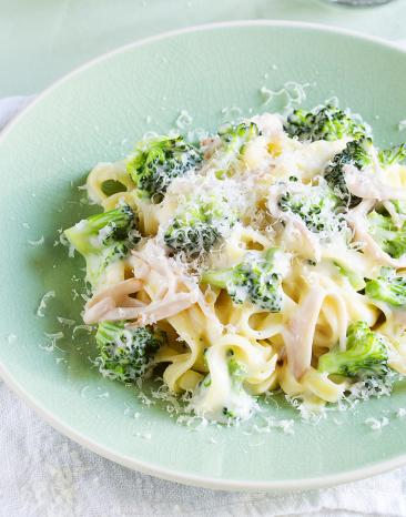 Pastagericht mit Brokkoli und Schinken auf einem Teller.