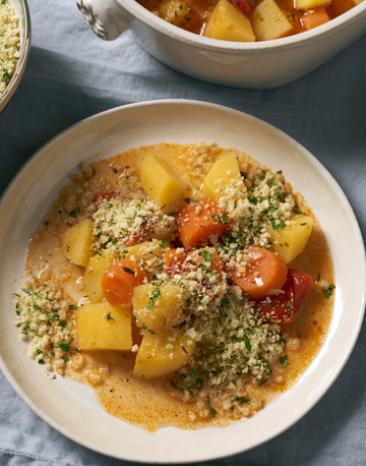 Kartoffelgulasch mit Gremolata auf einem Teller.