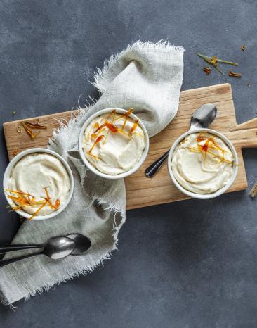 Helle Creme mit Karamell in kleinen Schüsseln.