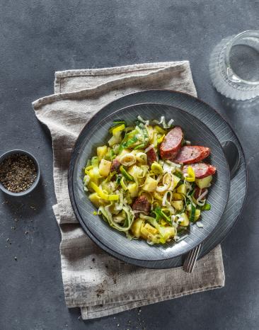 Kartoffel-Lauch-EIntopf mit Kohlwurst auf einem Teller.