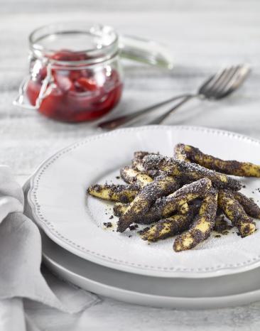 Schupnudeln mit eine Mohnschicht überzogen auf einem Teller.