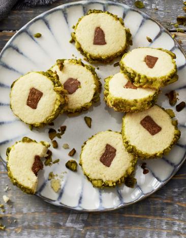 Plätzchen mit einem Nougatkern, in einem Keksteig umhüllt von Pistazien.